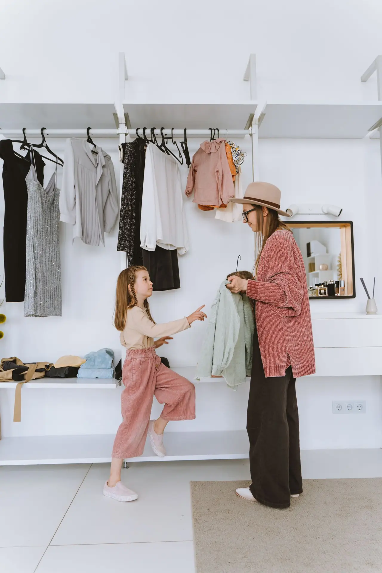 Mãe e filha escolhem roupas juntas diante do guarda-roupa