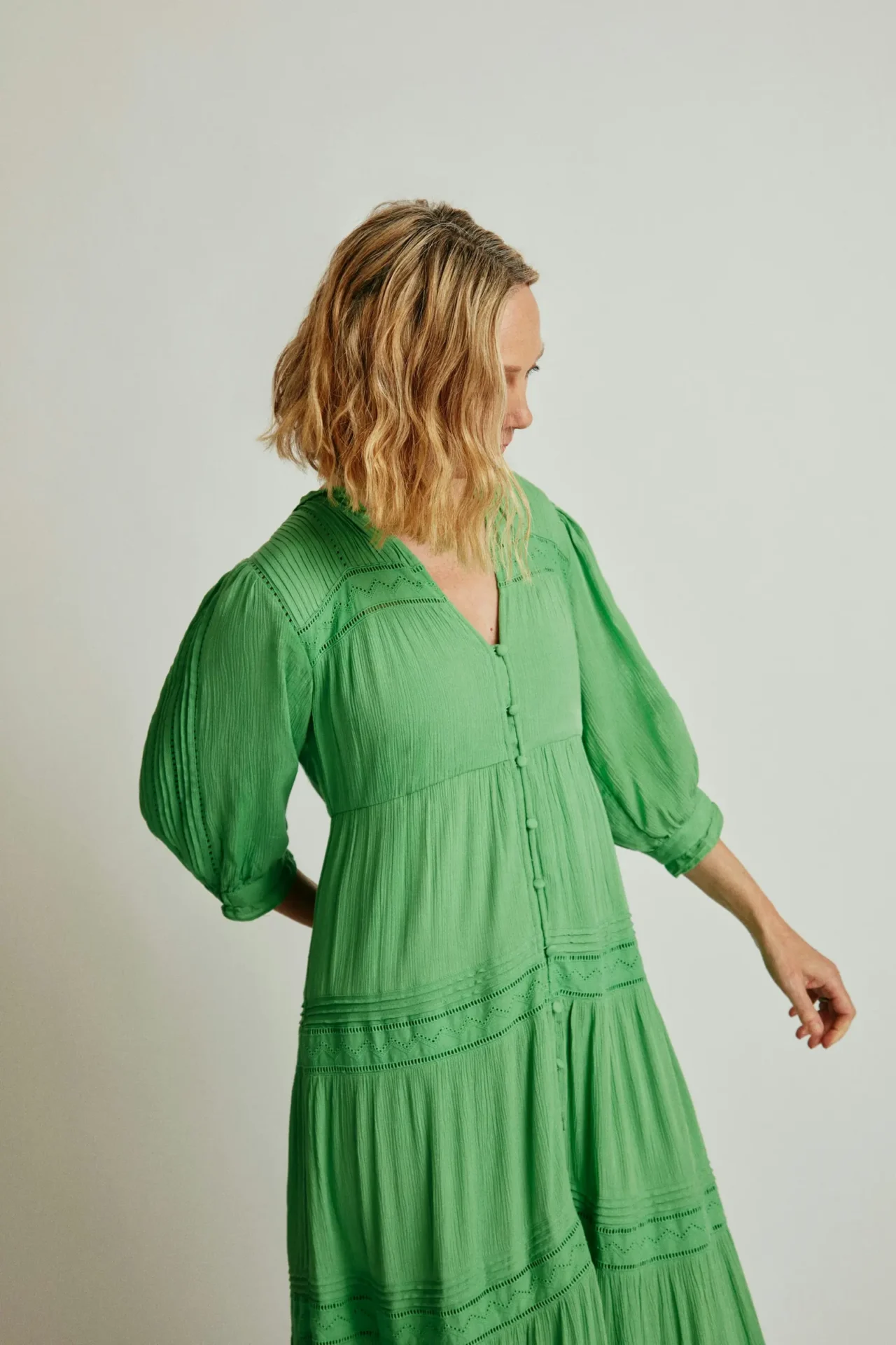 Mulher madura usa vestido verde claro de tecido fluido
